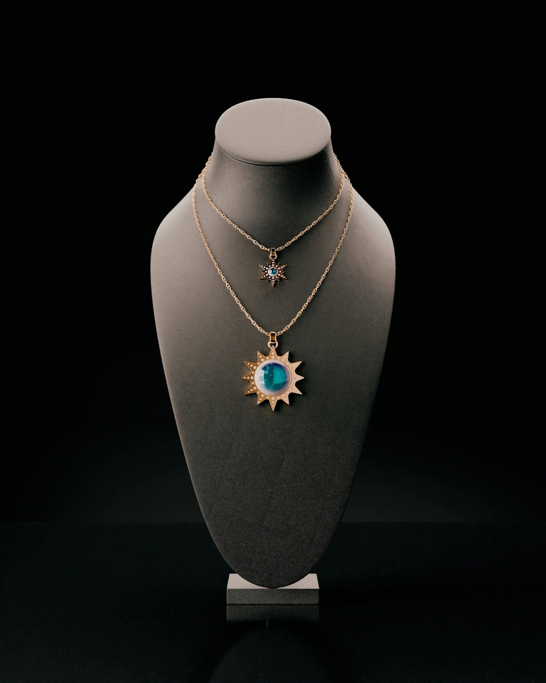 Two sun-shaped necklaces displayed on a bust