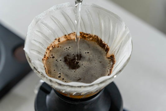a coffee pot filled with liquid on top of a stove